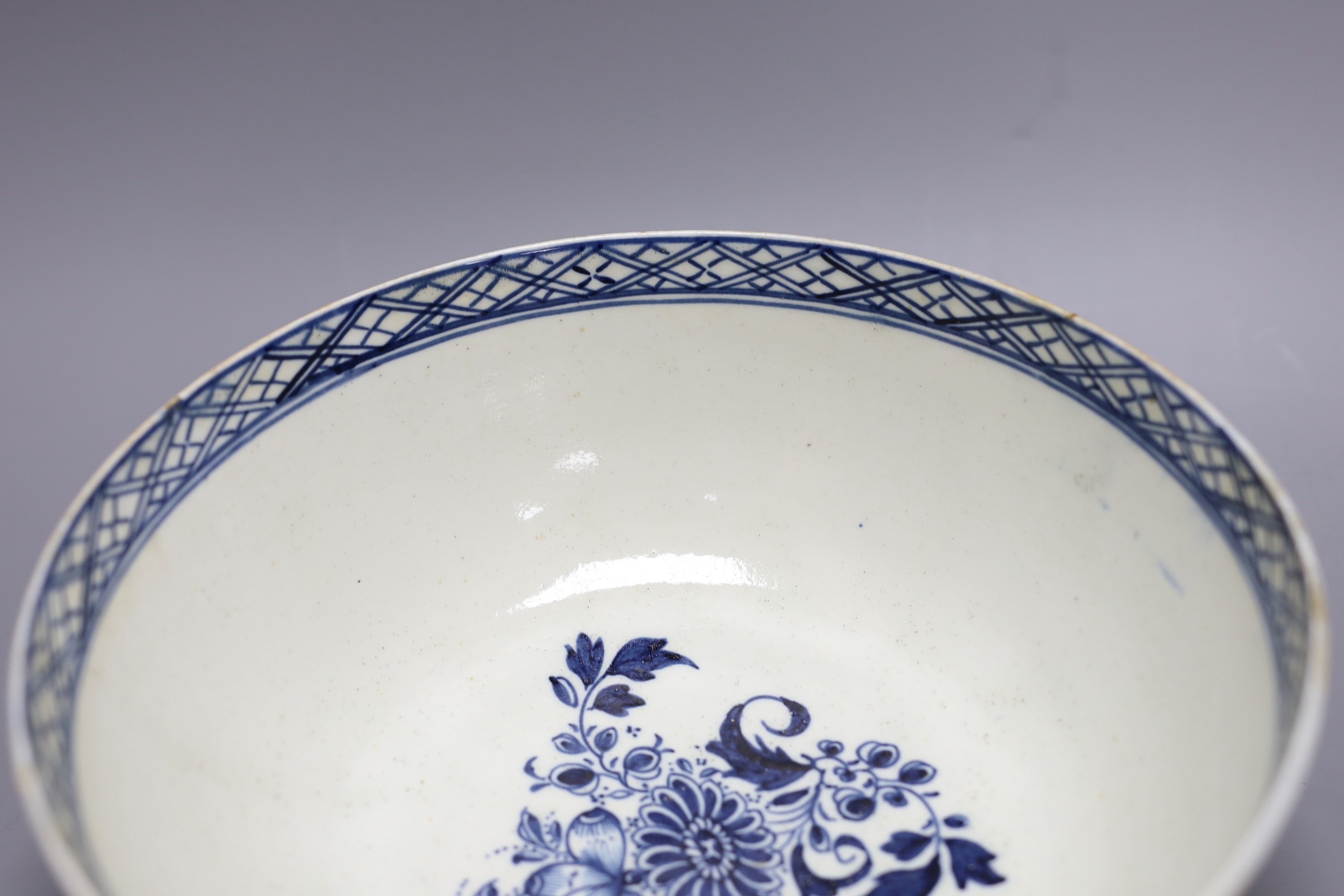 A Liverpool punch bowl, hand painted with flowers and a fence in blue underglaze, 23cm diameter